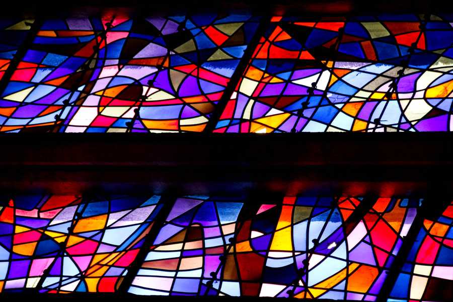 A kaleidoscope of colours in a stained glass panel - blues, purple, oranges and red.