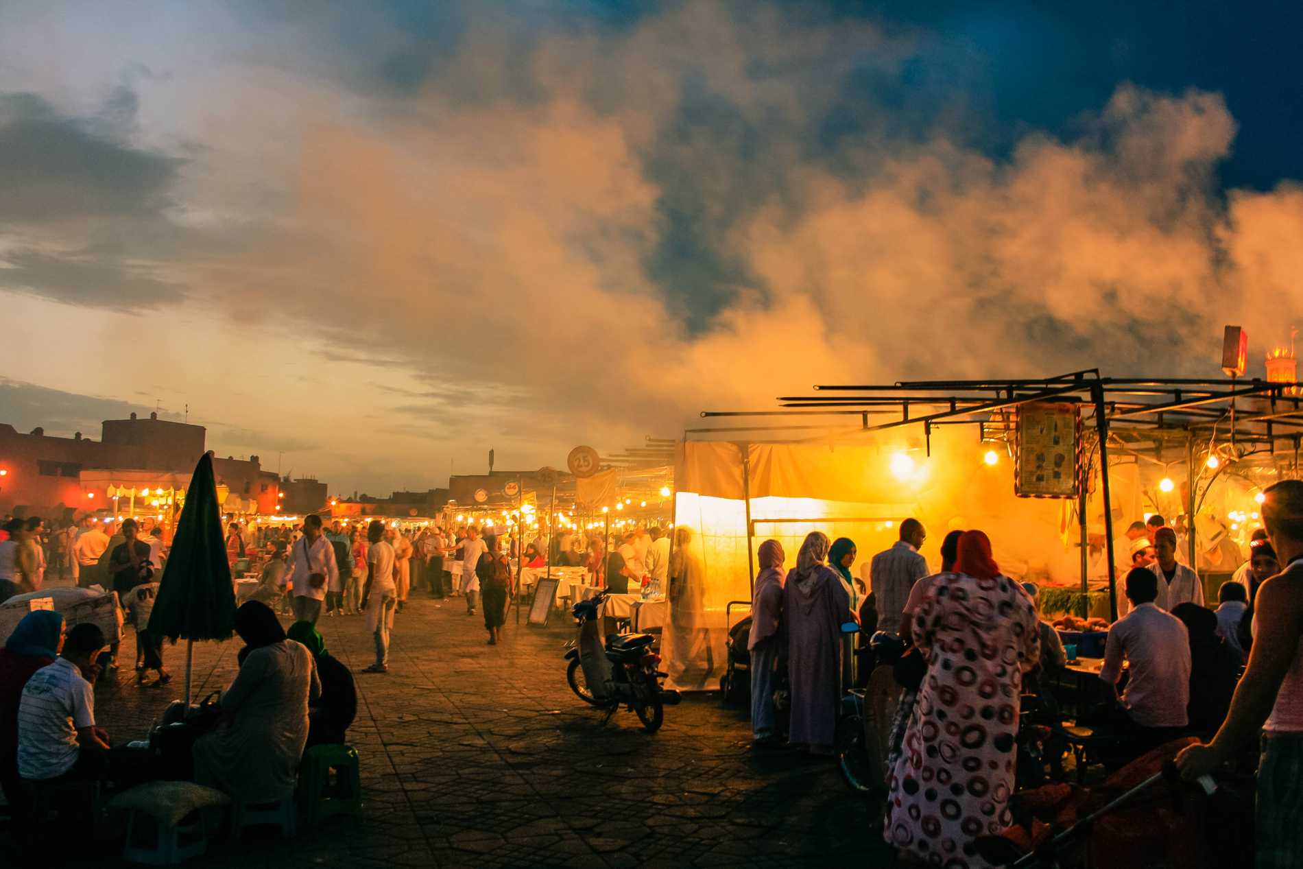 The main square (Jemaa el-Fnaa) in Marrakech glows at night with the fires of street vendors cooking food.