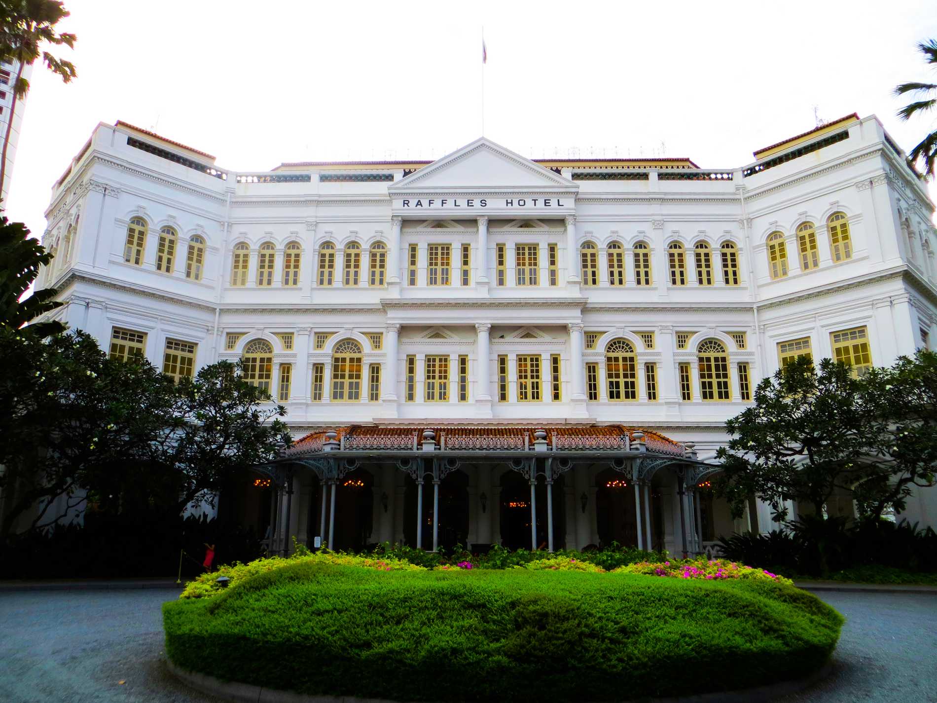 The bright white, colonial-style façade and entrance to Raffles Hotel.